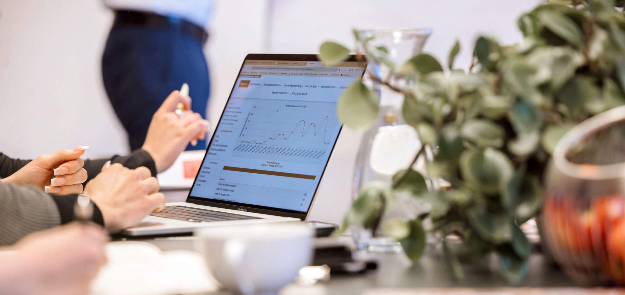 Eine Frau sitzt an einem Laptop und schaut sich eine Grafik im Analysetool Checkeffect an